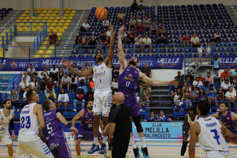 Jugadores de baloncesto en el salto inicial durante un partido