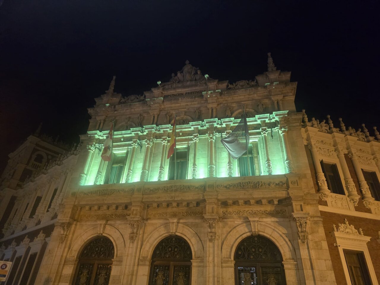 Fachada iluminada de la Diputación de Palencia en color verde
