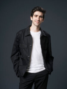 Lalo Tenorio posando con una chaqueta negra y camiseta blanca