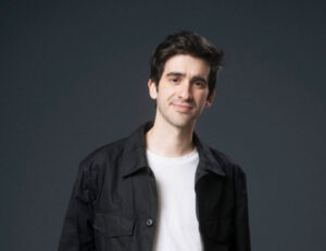 Lalo Tenorio posando con una chaqueta negra y camiseta blanca