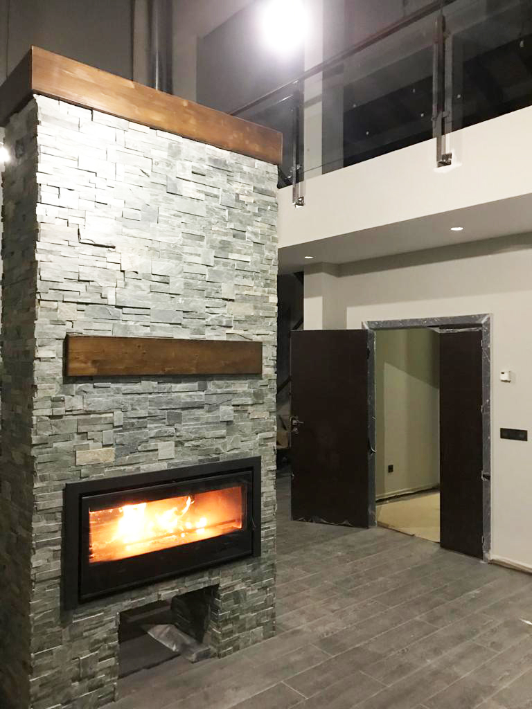 Estufa de pellets en un ambiente moderno con paredes de piedra.