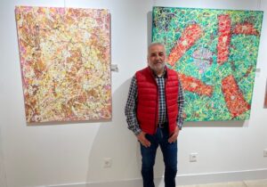 Pintor Juan Pedro López junto a sus obras abstractas en el Ateneo de Palencia.