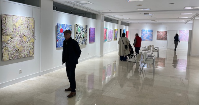 Visitantes observando obras abstractas en la exposición de Juan Pedro López