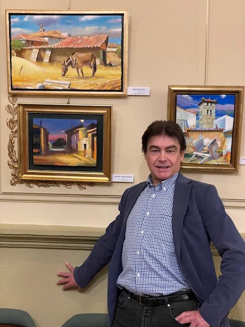 Luis Javier Meneses junto a sus pinturas en el Casino de Palencia