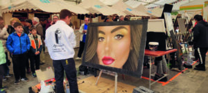 Artista pintando un retrato en una feria de decoración en Guardo