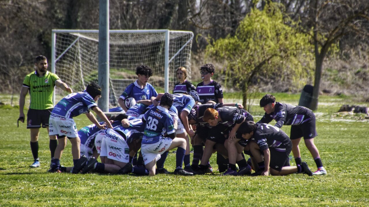 Jugadores en formación de melé durante un partido de rugby sub-14
