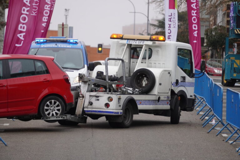 Grúa municipal levantando un coche en una calle de Palencia