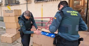 Agentes de la Guardia Civil inspeccionando cajas de zapatillas incautadas