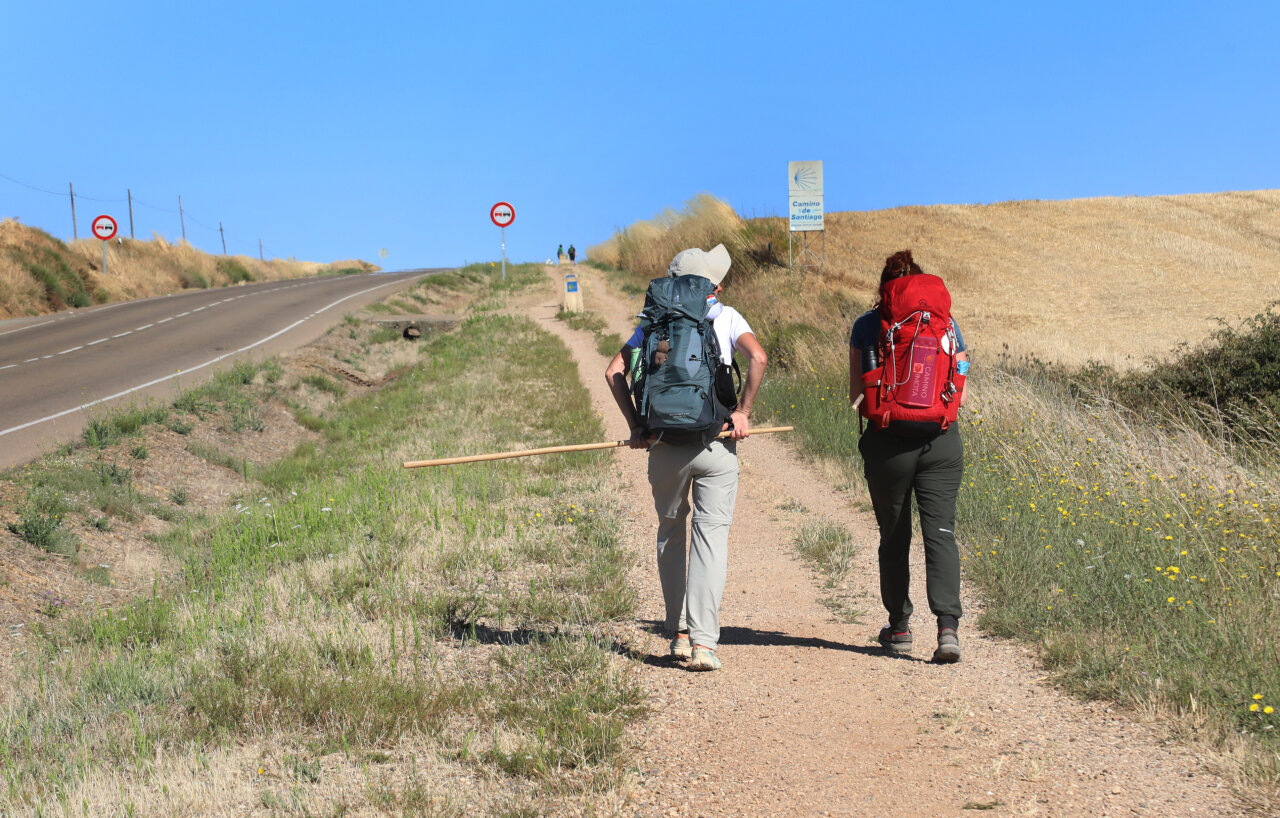 Dos peregrinos caminando por el Camino de Santiago en Palencia