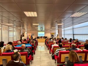 Asistentes a jornadas sobre extranjería en Palencia, con ponentes y público en sala.