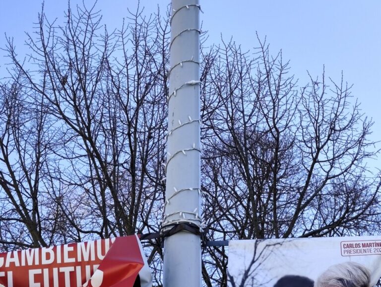 Farola con luces navideñas en Palencia bajo un cielo azul