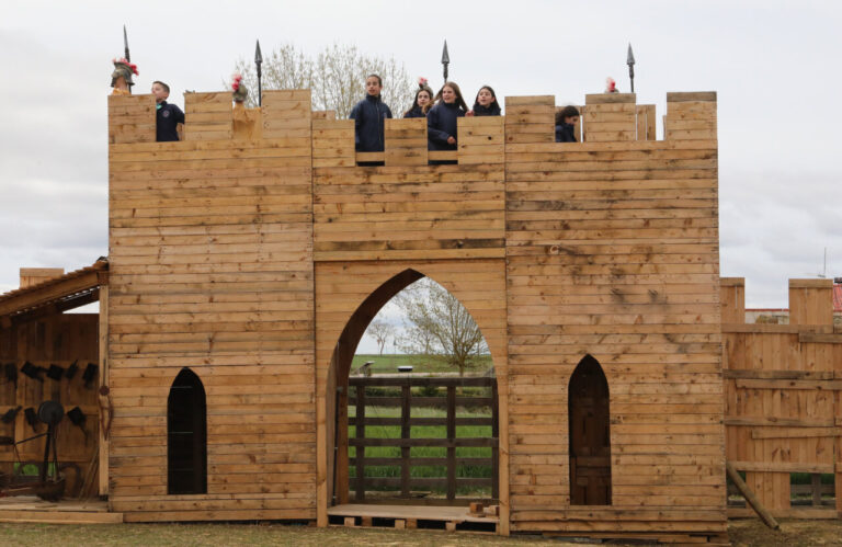 Niños y adultos en un castillo de madera en Marcilla de Campos
