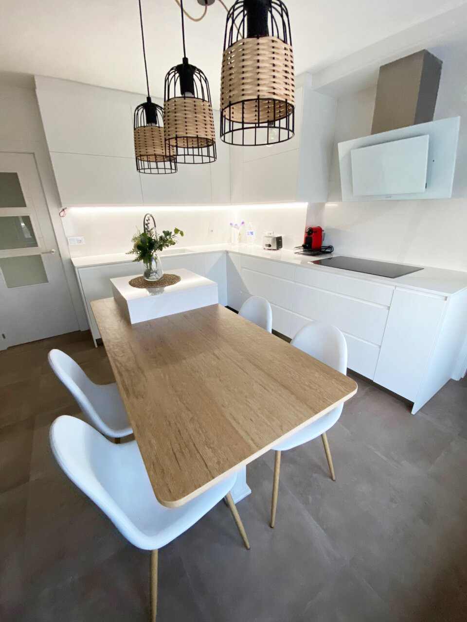 Cocina moderna con mesa de madera y sillas blancas