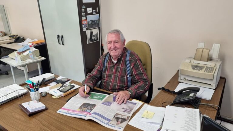 Paco Álvarez de la Lama sentado en su oficina leyendo un periódico