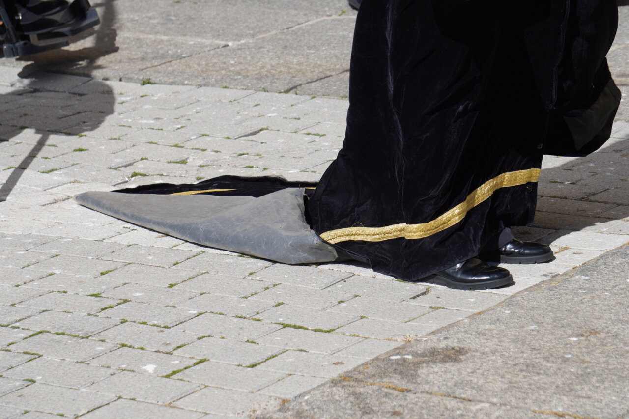 Detalle de un cofrade con túnica negra y dorada en Palencia