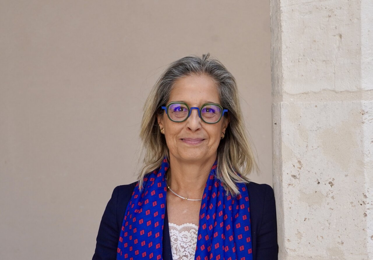 Pilar Garcés, catedrática de Filología Inglesa, sonriente en un entorno académico.