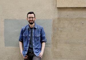 Miguel Ángel Llamas posando frente a una pared con colores neutros