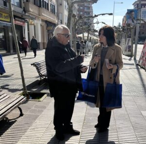 Mercedes Cófreces hablando con un hombre mayor en la calle de Palencia