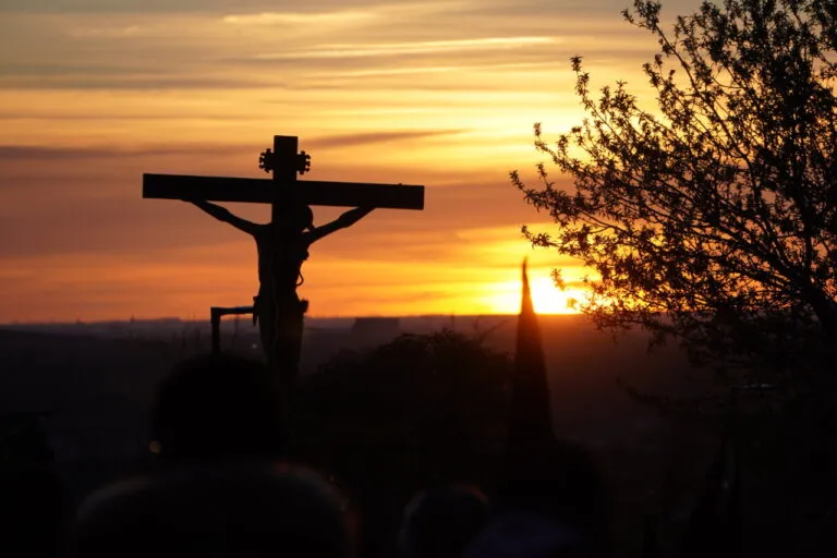 Silueta de la cruz con el Cristo al atardecer durante la procesión del Rosario del Dolor