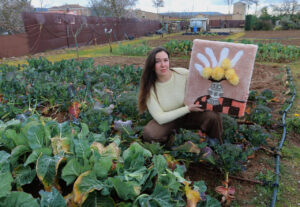Mujer sosteniendo una obra de arte en un huerto tradicional