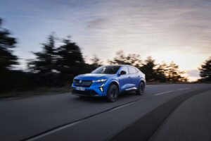 Renault Austral en movimiento por carretera con paisaje de fondo