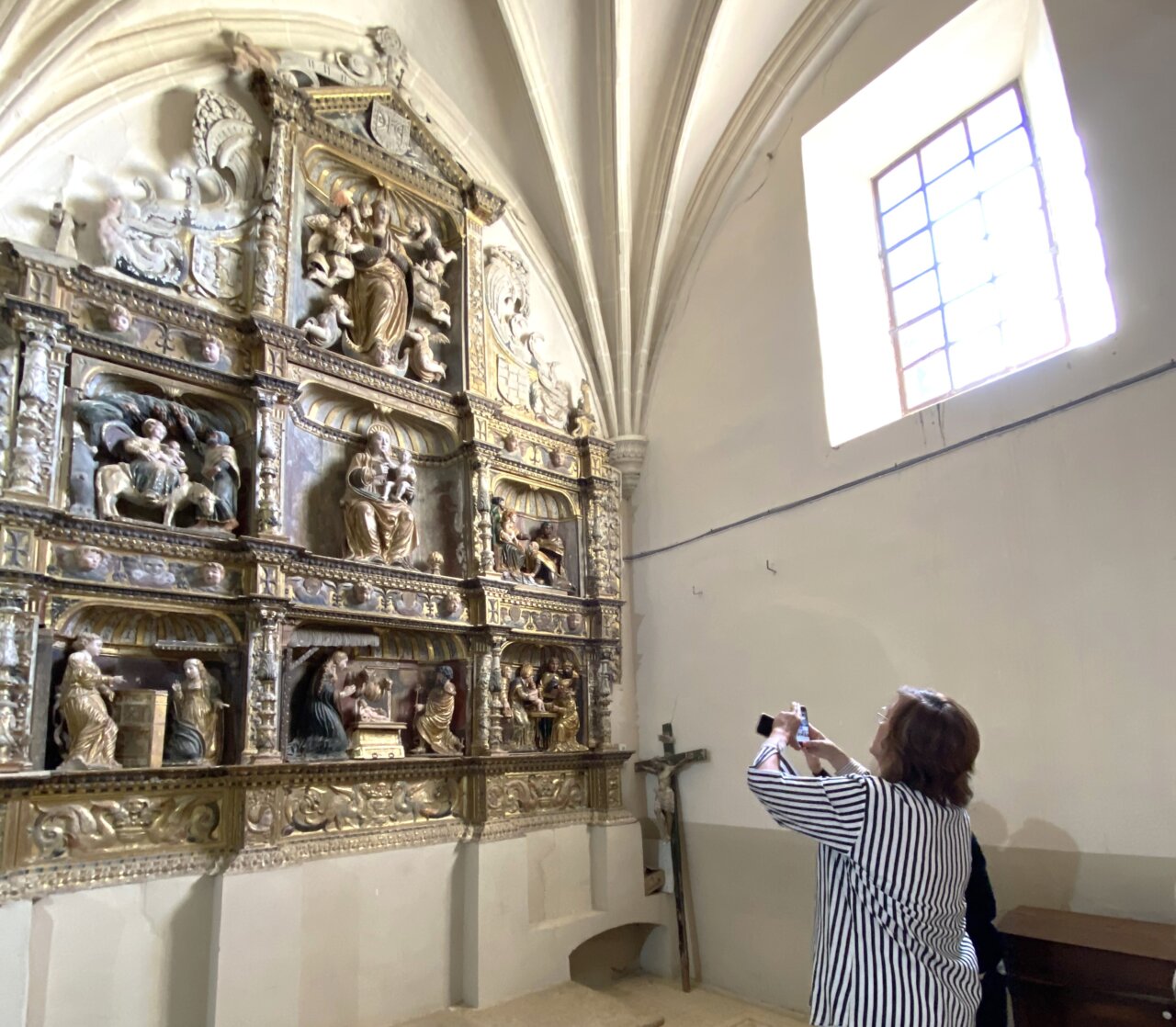 Persona fotografiando un retablo en una iglesia de Palencia