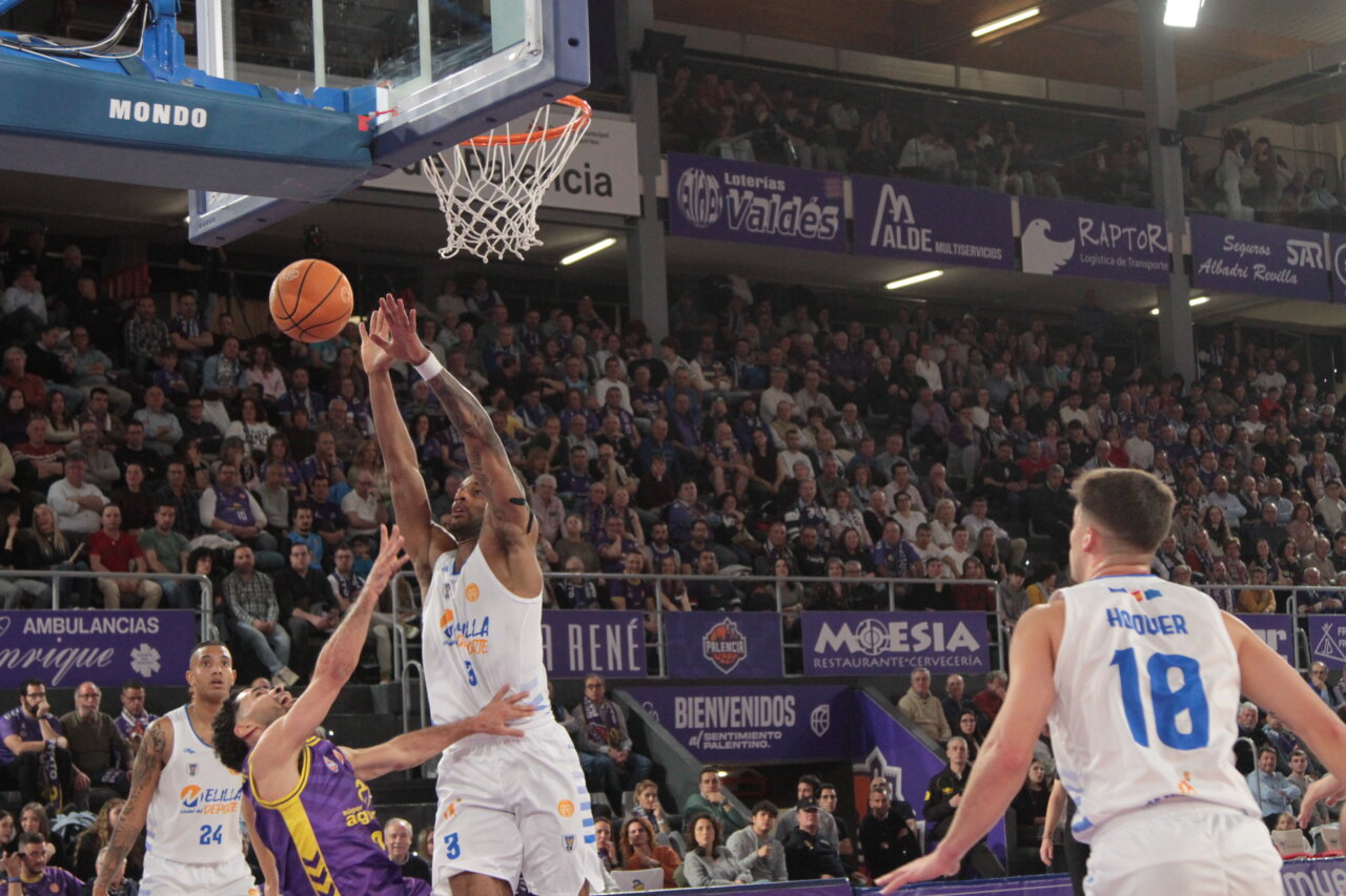 Jugadores de baloncesto en acción durante un partido entre Palencia y Melilla.