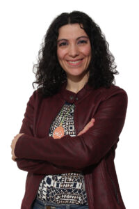 Tatiana Lean, candidata del partido Por Un Mundo Más Justo, sonriendo con brazos cruzados.