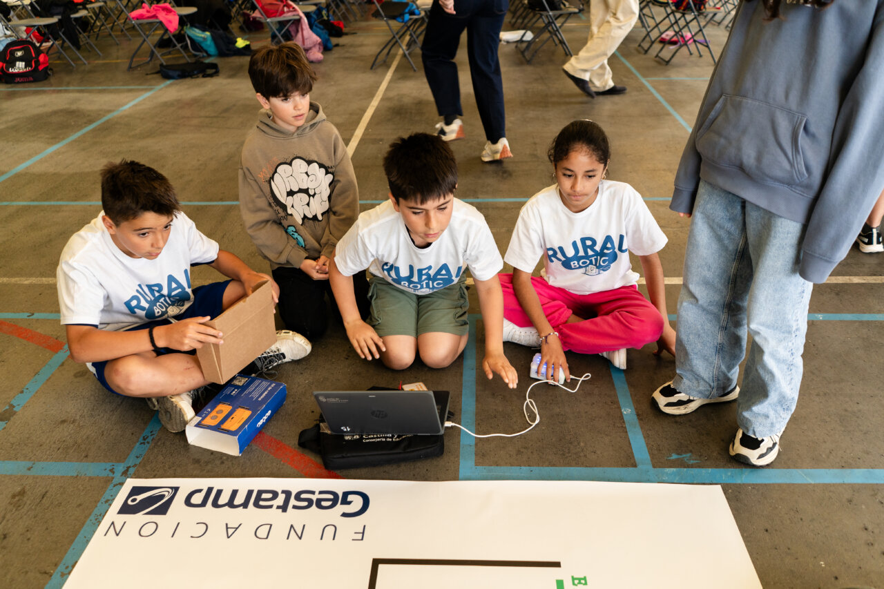 Niños participando en un torneo de robótica rural con kits educativos
