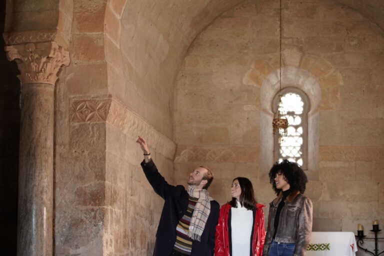 Grupo de personas en la iglesia de San Juan de Baños observando detalles arquitectónicos