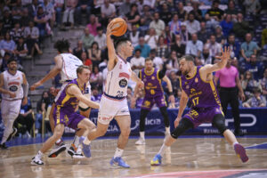 Jugadores de baloncesto en acción durante un partido entre Monbus Obradoiro y Super Agropal Palencia.