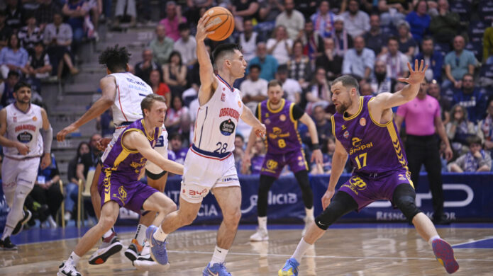 Jugadores de baloncesto en acción durante un partido entre Monbus Obradoiro y Super Agropal Palencia.