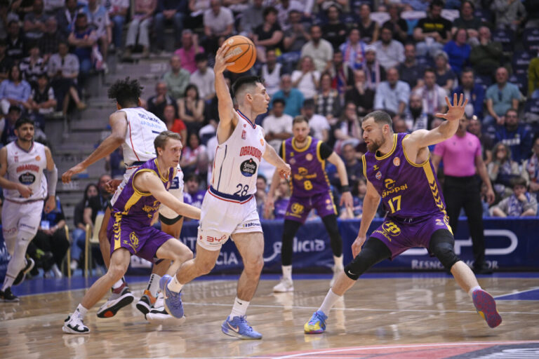 Jugadores de baloncesto en acción durante un partido entre Monbus Obradoiro y Super Agropal Palencia.