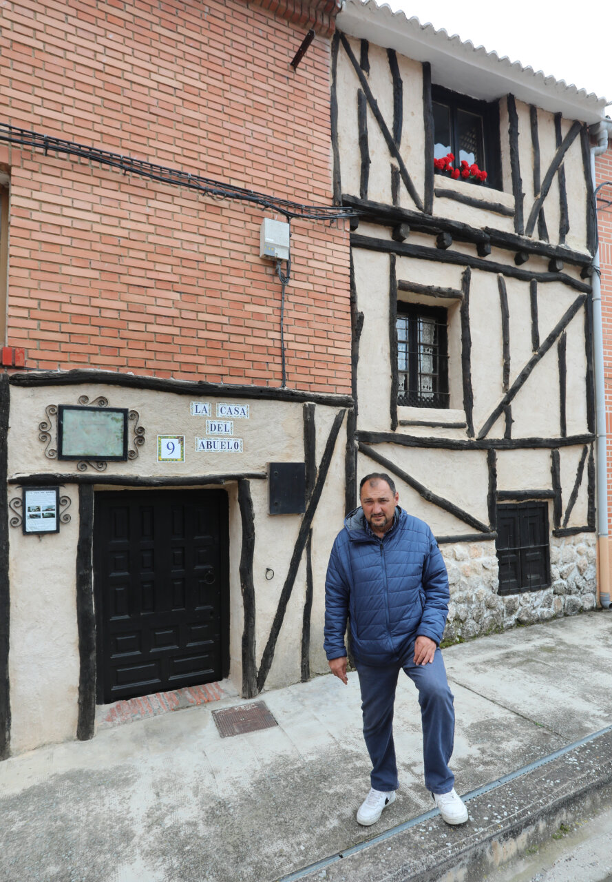 Fachada de La Casa del Abuelo en Cevico de la Torre con un hombre de pie.