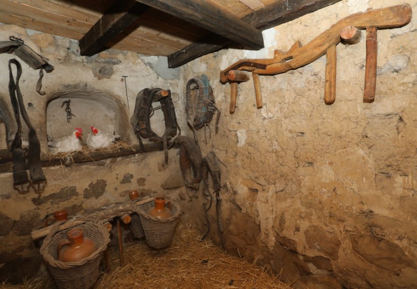 Interior de La Casa del Abuelo con objetos antiguos y gallinas