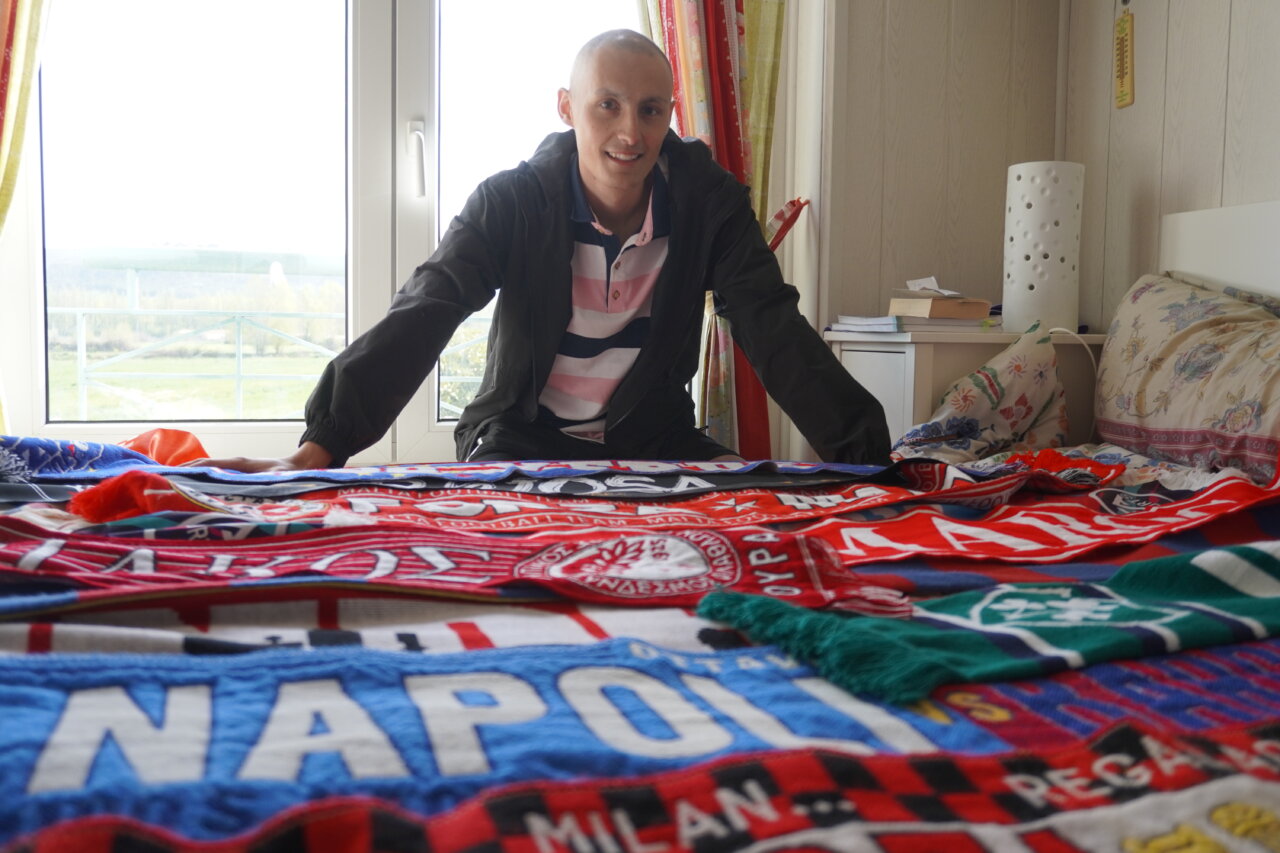 Mario Martínez, jugador de fútbol, rodeado de bufandas en su habitación