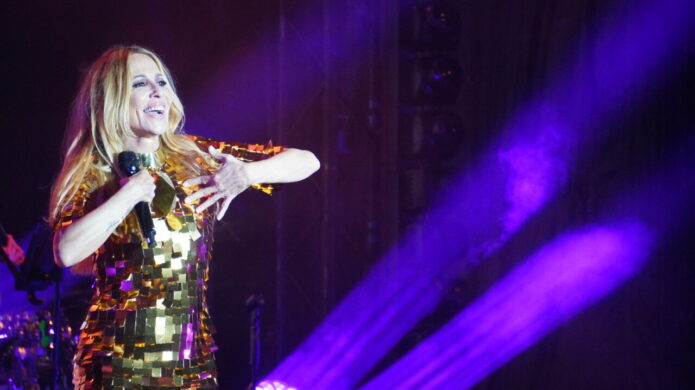 Marta Sánchez en concierto con vestido brillante y micrófono en mano