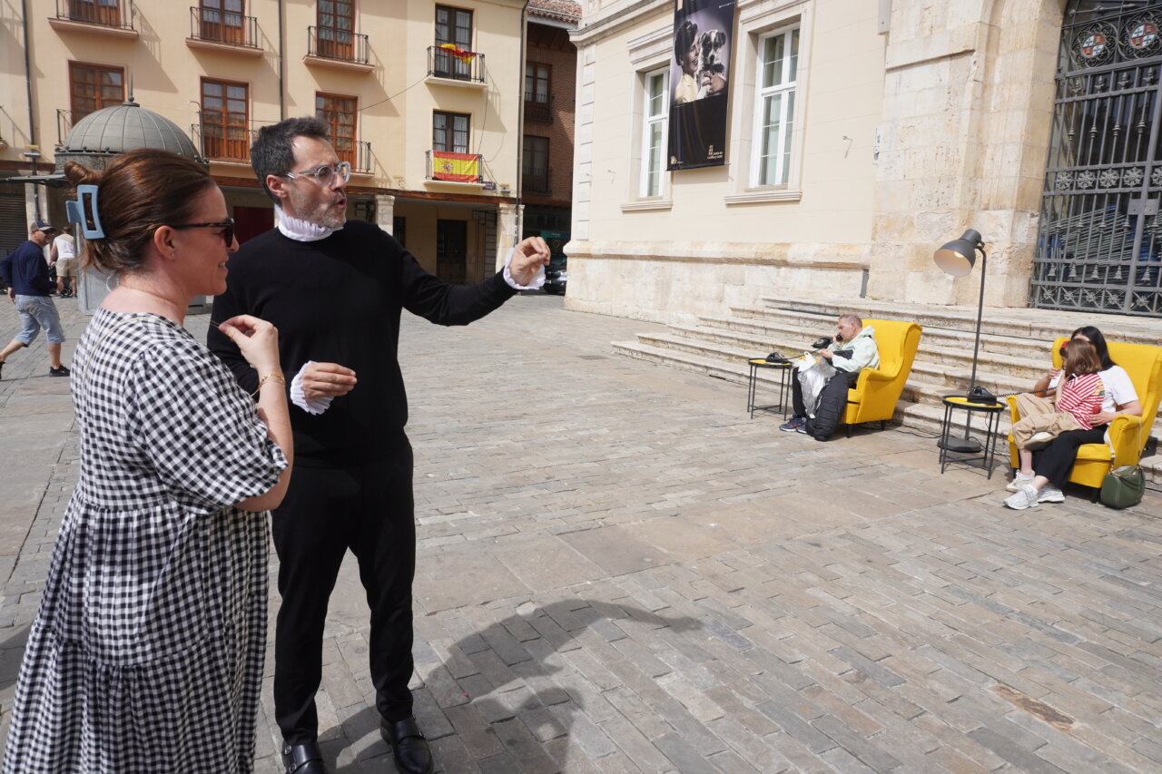 Dos personas conversando en una plaza con sillones amarillos