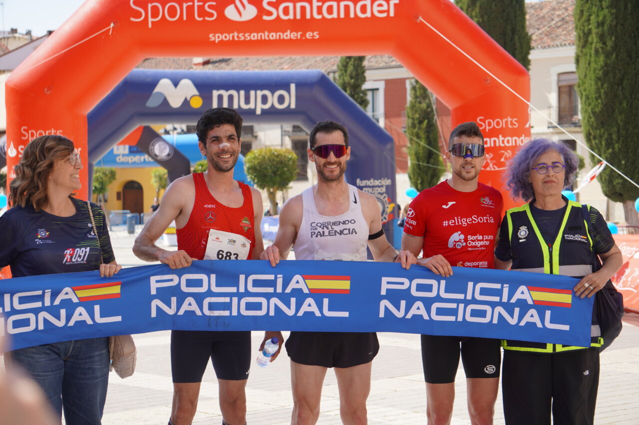 Participantes de la carrera con bandera de Policía Nacional en Palencia.