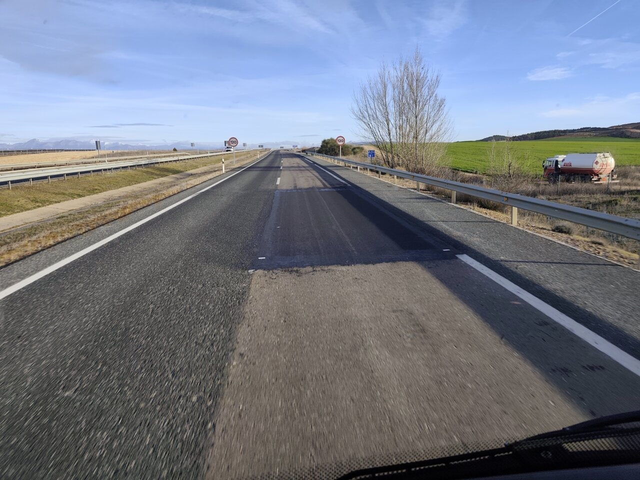 Vista de la autovía A-67 con diferentes tonos de gris en el asfalto