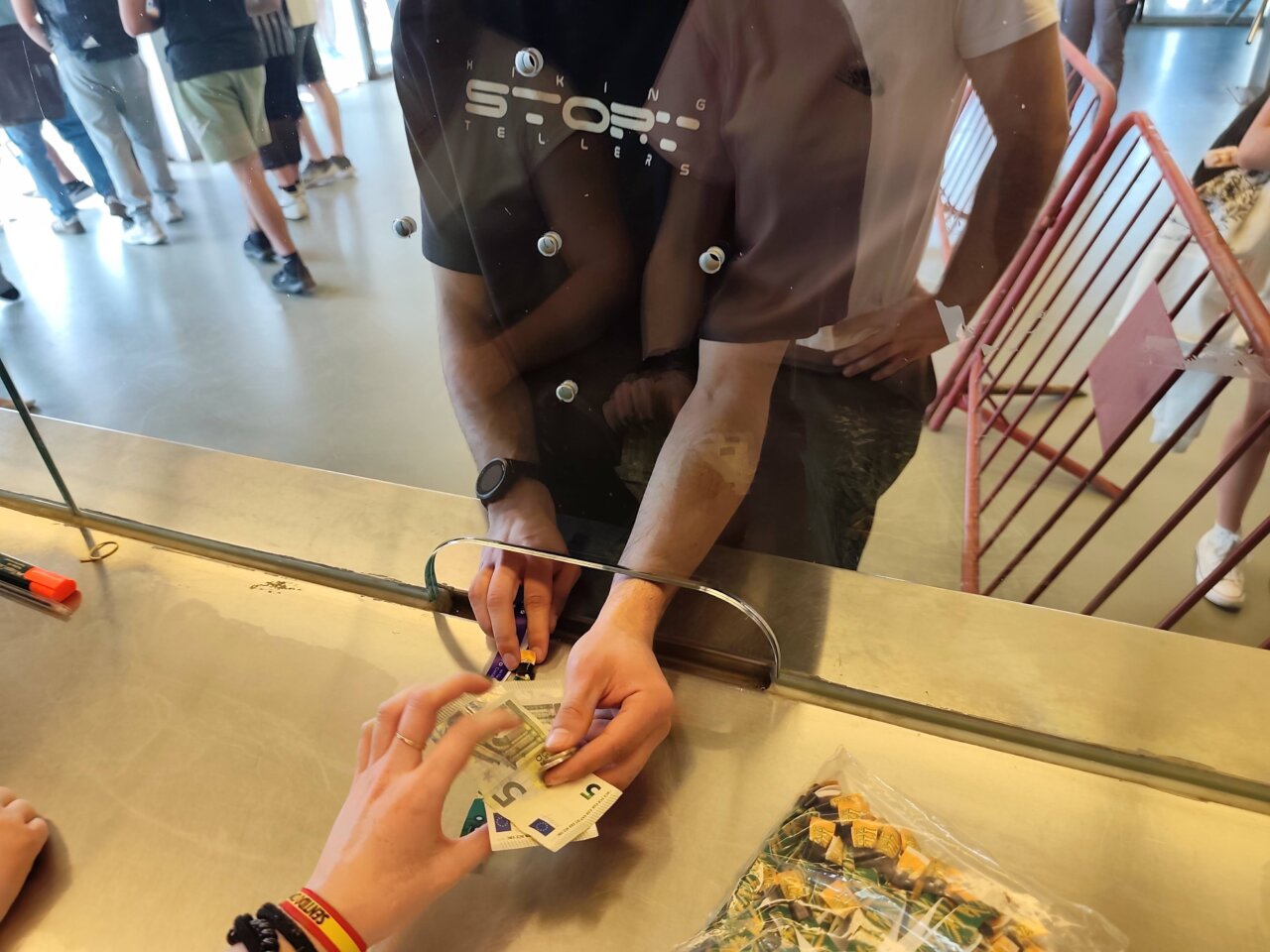 Persona comprando entradas en taquilla con billetes en la mano