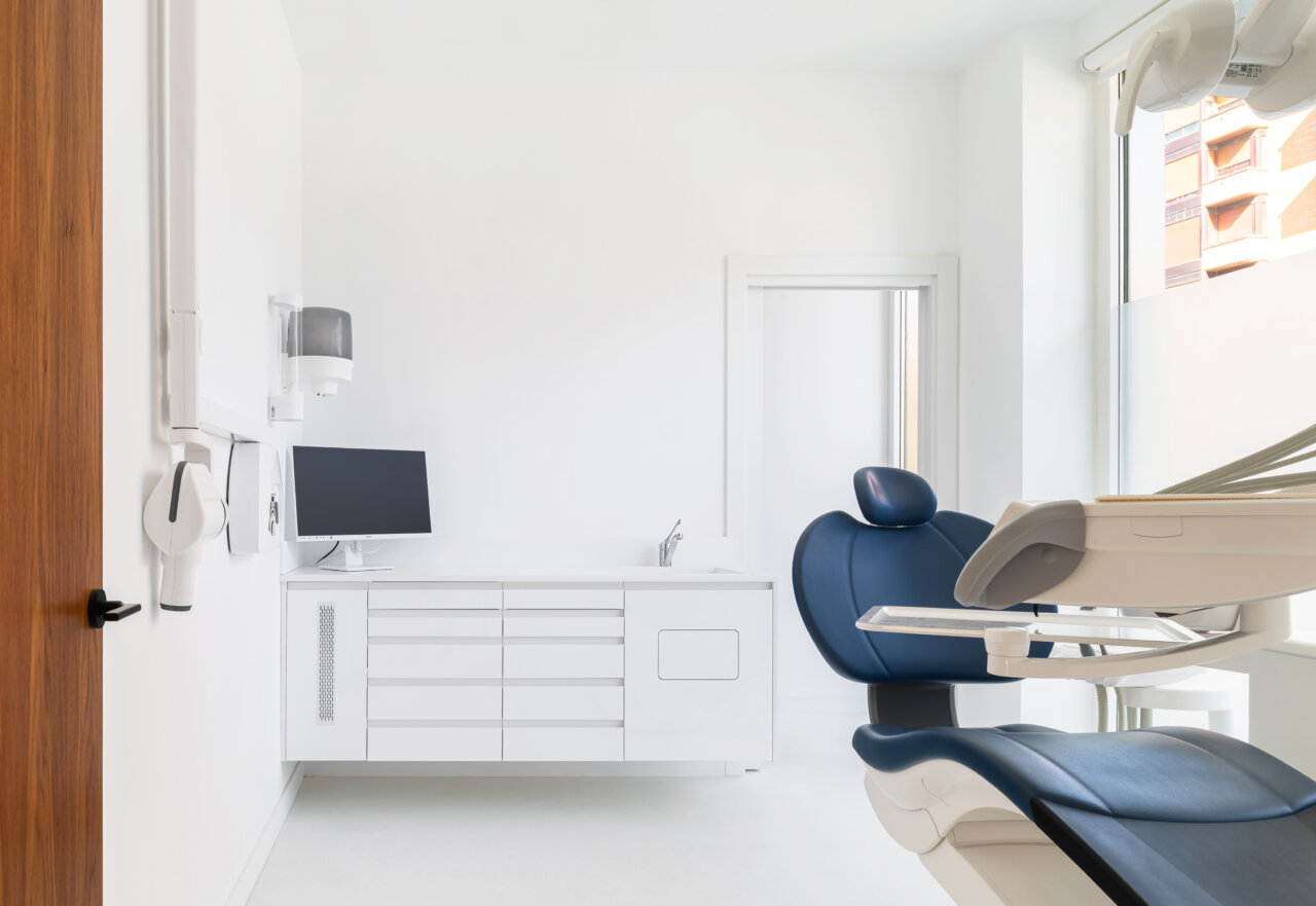 Interior de la Policlínica Dental by Pérez y Arroyo con silla dental y monitor.