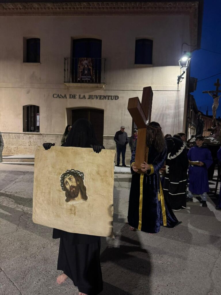 Participantes en la procesión del Jueves Santo en Astudillo con cruz y estandarte