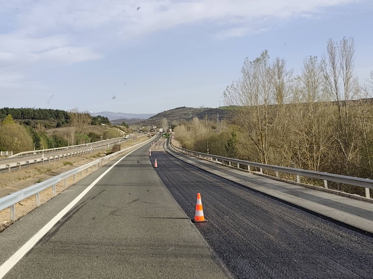 Vista de la autovía A-67 en proceso de asfaltado con conos de señalización