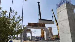 Obras del salto de carnero con grúas izando vigas en Palencia