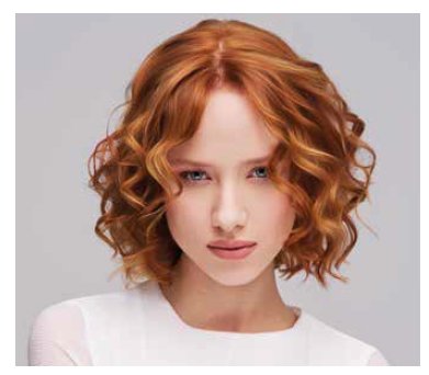 Mujer con cabello rizado y color rojo en un fondo neutro