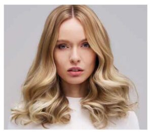 Mujer con cabello rubio y ondas suaves en un fondo neutro