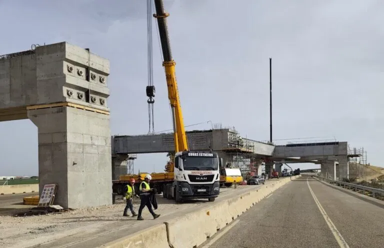 Obras en la A-67 con grúas y trabajadores en el viaducto
