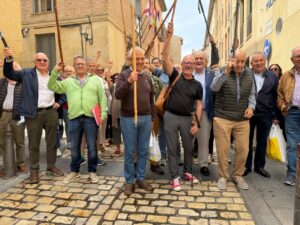 Grupo de personas levantando bastones durante la asamblea del Camino Francés en Logroño