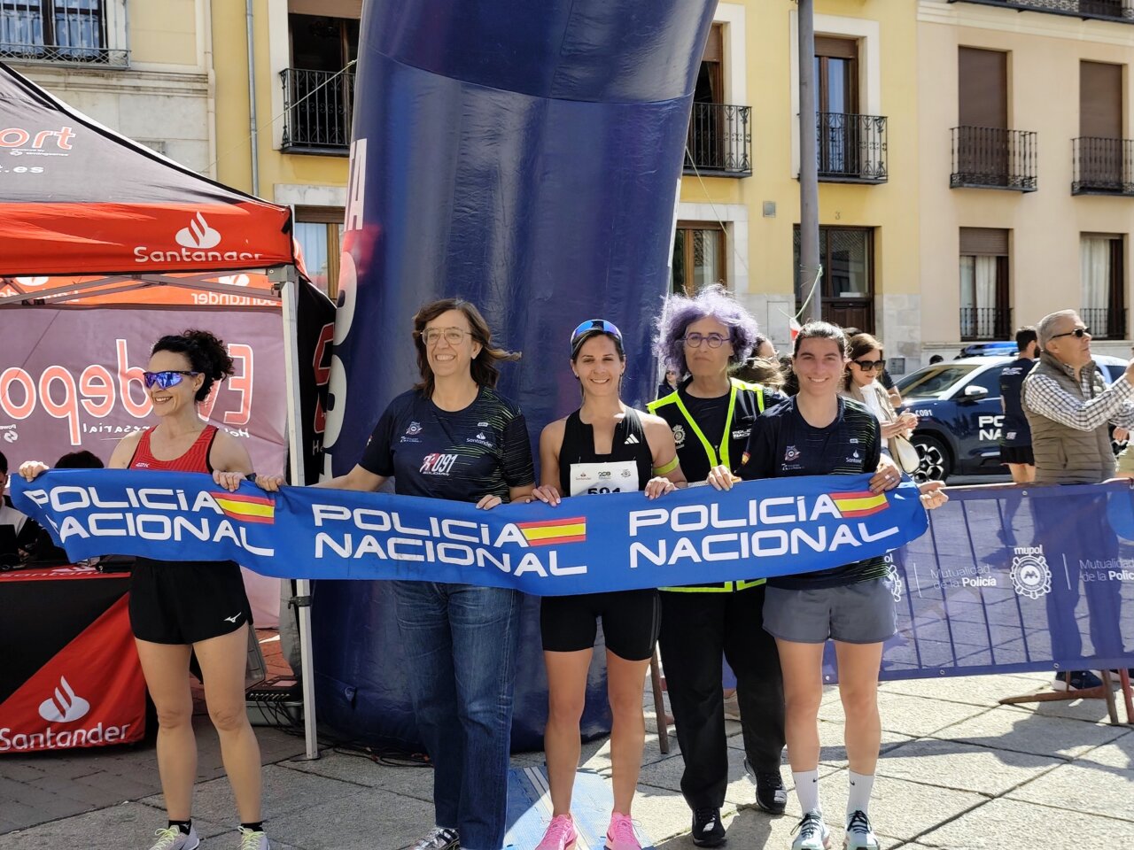 Participantes de la carrera con bandera de la Policía Nacional